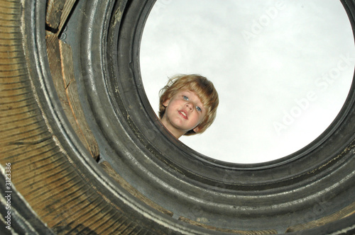 girl looking through tires 2