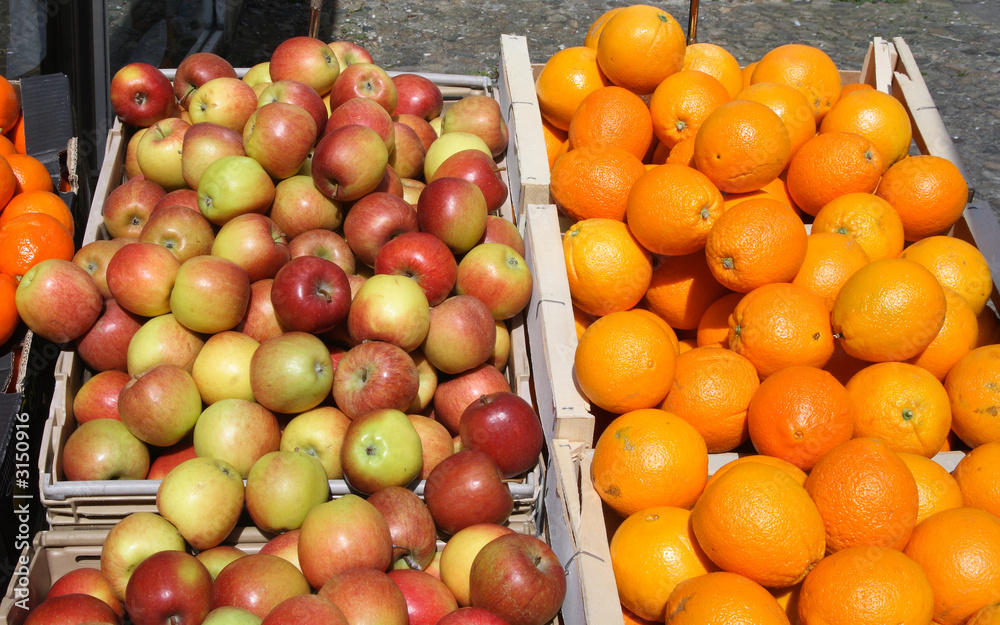 apples and oranges outside a british grocery shop. apples and oranges outside a british grocery shop.