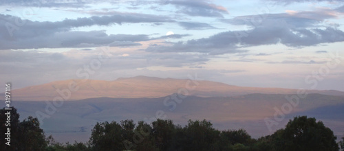 sunset in the african savanna with red mountains in the backgrou