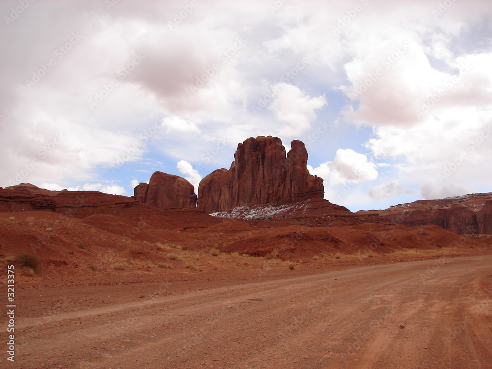 pink clouds and a dirt track in monument valley