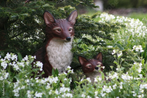 two ceramic foxes in a garden