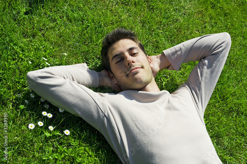 jeune homme sourire détente relaxation l' herbe
