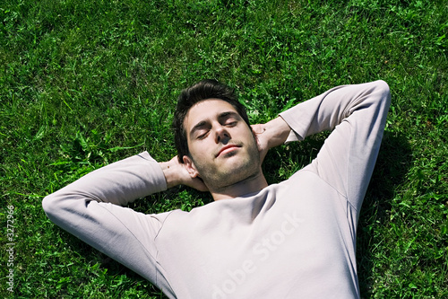 jeune homme sieste dans l'herbe repos relaxation