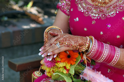 hands of a indian bride with henna design and bang