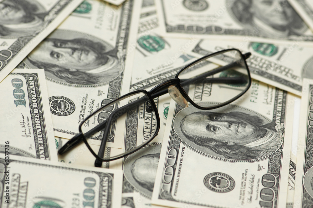 reading glasses over hundred dollar bank notes reading glasses over hundred dollar bank notes