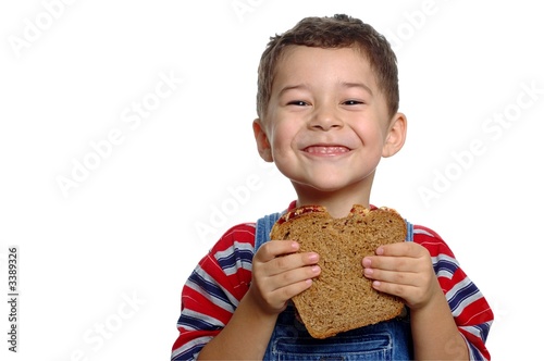 boy with peanut butter sandwich on whole wheat bre