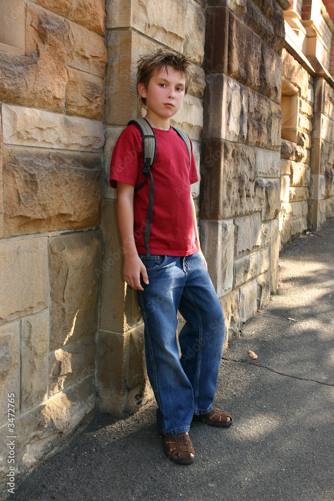 youth leaning against sandstone wall