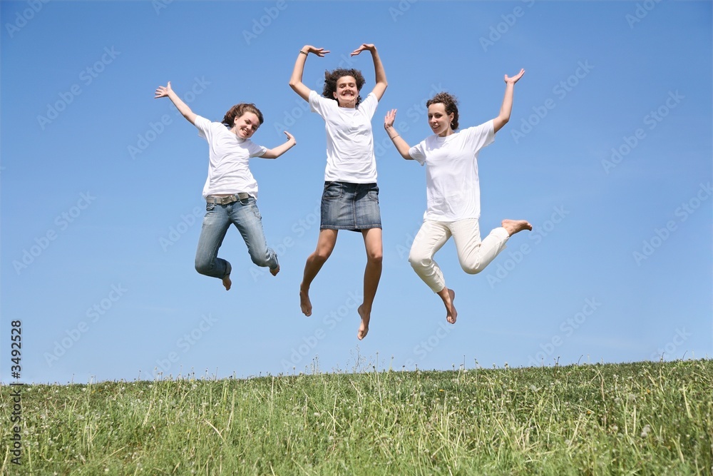 Three girlfriends in white T-shorts jump simultaneously Three girlfriends in white T-shorts jump simultaneously
