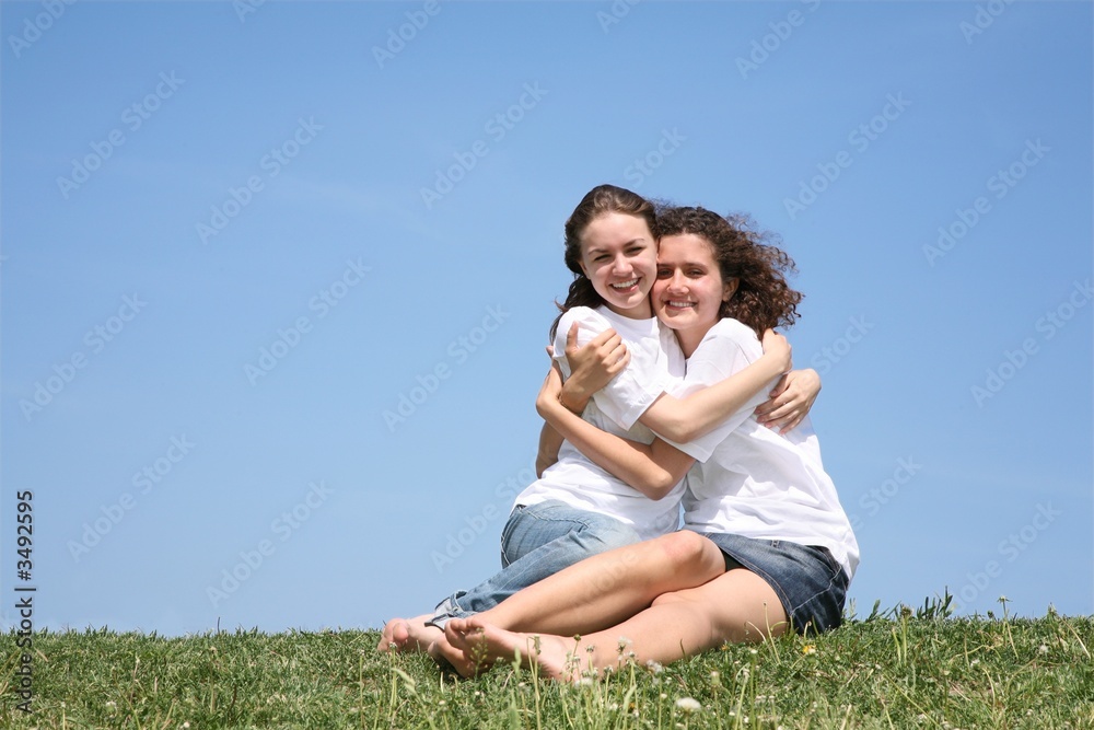 Two girlfriends in white T-shorts embrace Two girlfriends in white T-shorts embrace