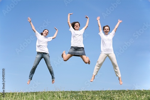 Three girlfriends in white T-shorts jump together