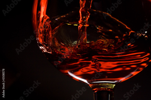 red wine pours into a glass