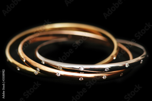 three gold bracelets isolated on the white