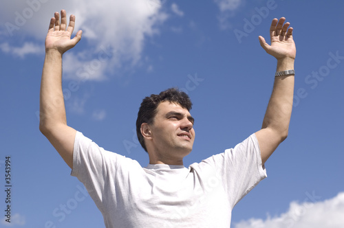 man on blue sky. hand up