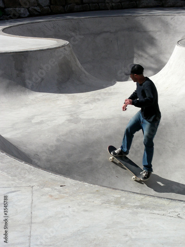 Skate boarder speeding up a bowl in a skatepark