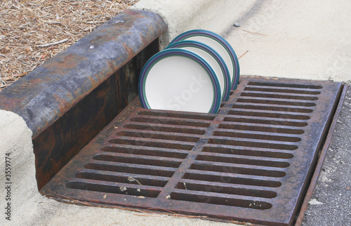 Plates drying in a storm drain grate. photo