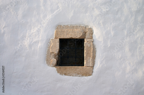 Принти на полотні small window with grate in white lime wall