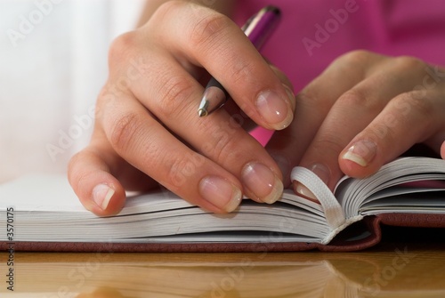 Nice hands with french manicure on the notebook.