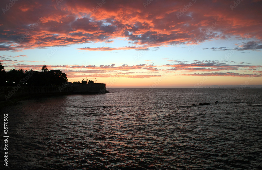 sunset over the sea with old castle and clouds