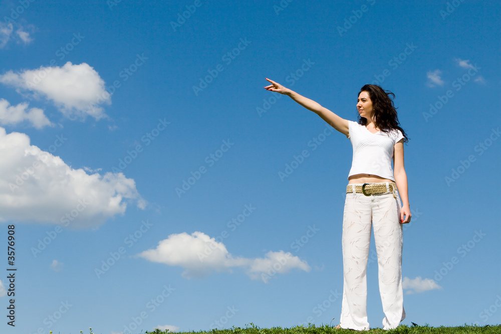 young woman on a green meadow and show something young woman on a green meadow and show something