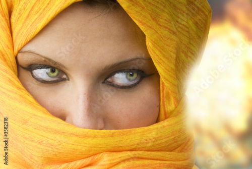 attactive and strong eyes behind an orange scarf photo