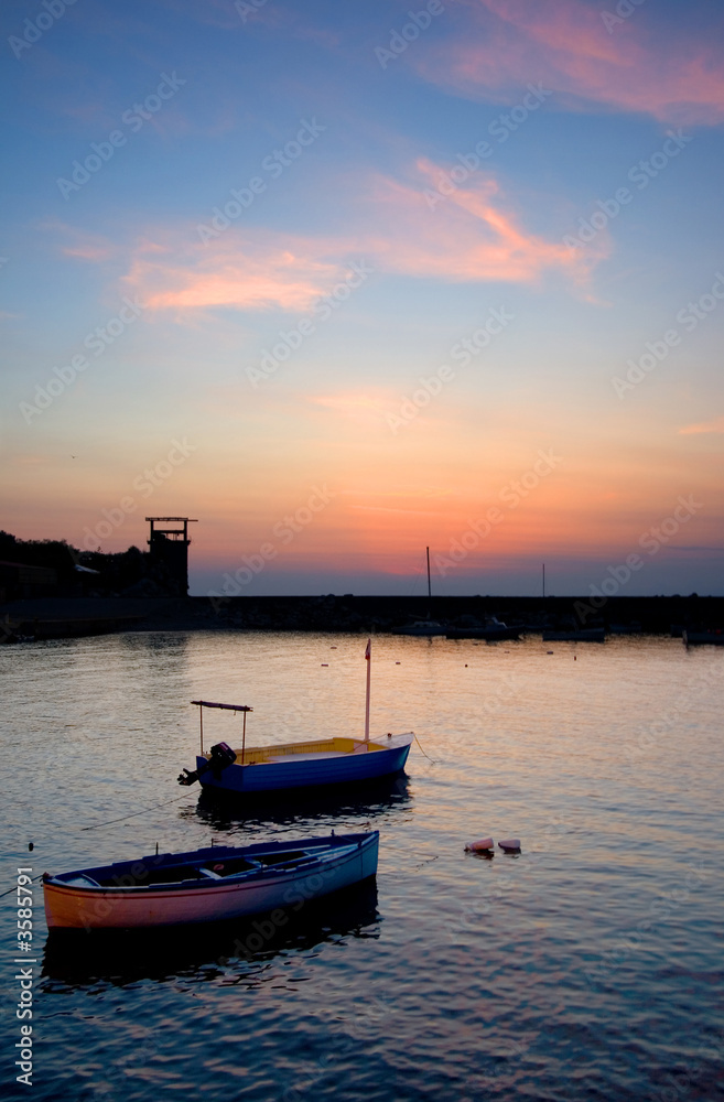 Beautiful sunset at a marina with small boats in the foreground