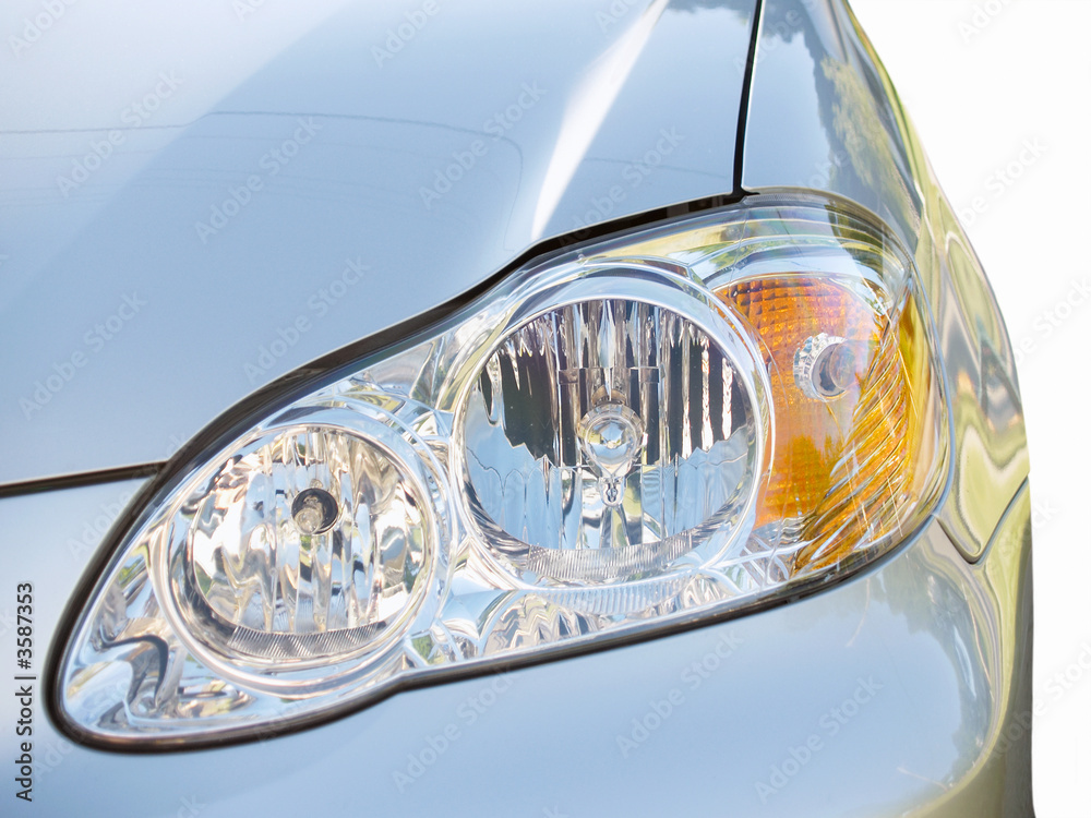 Close-up of headlight on a silver car, isolated Close-up of headlight on a silver car, isolated