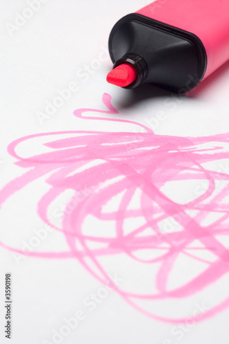 A pink highlighter pen scribbles onto paper.