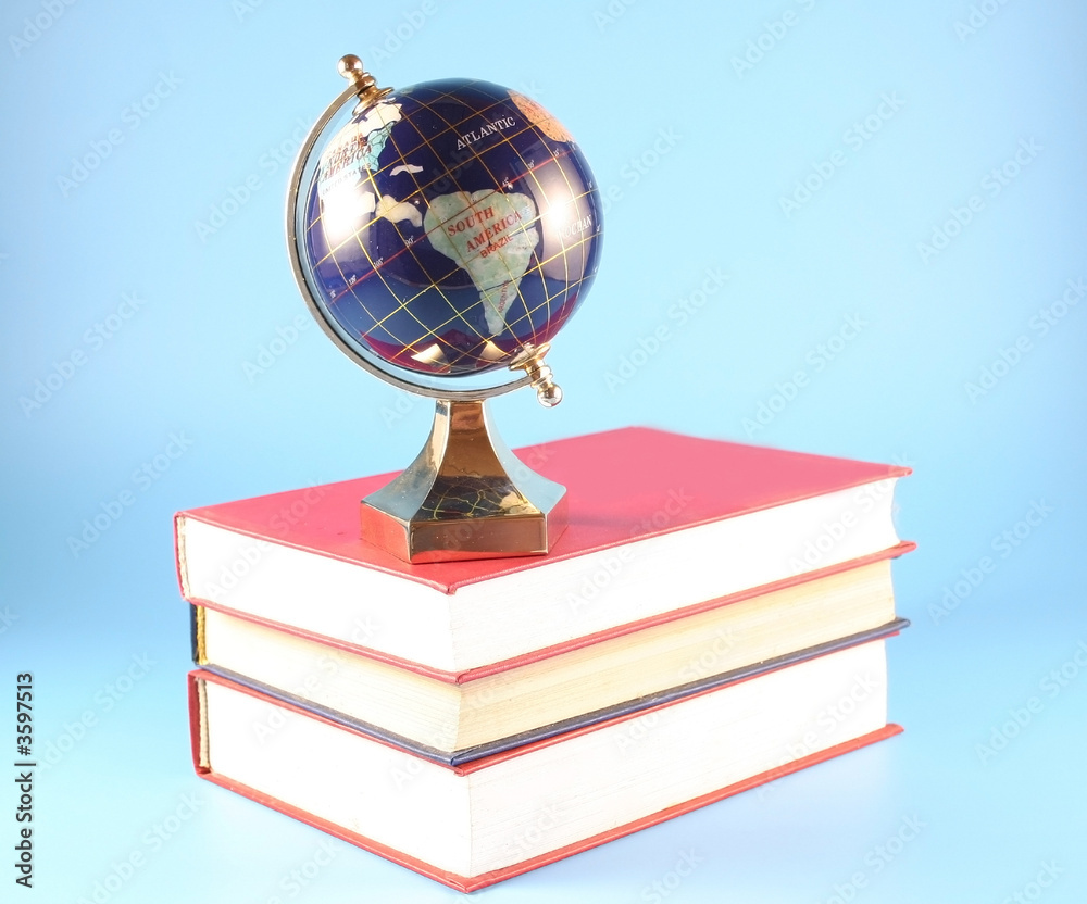 Globa costs on a pile of books on a blue background Globa costs on a pile of books on a blue background