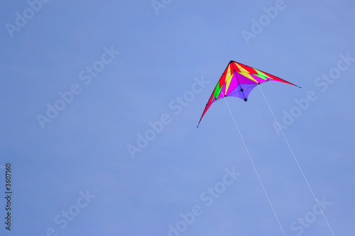 Flying kite against a deep blue sky