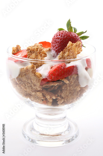 glass of yogurt fresh strawberries and cereals on white