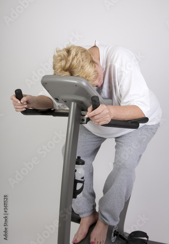 tired woman on excercise bike after workout