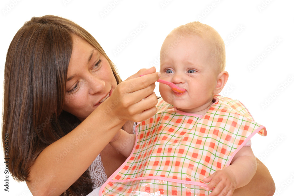 mother and 8 months baby girl with baby food isolated mother and 8 months baby girl with baby food isolated