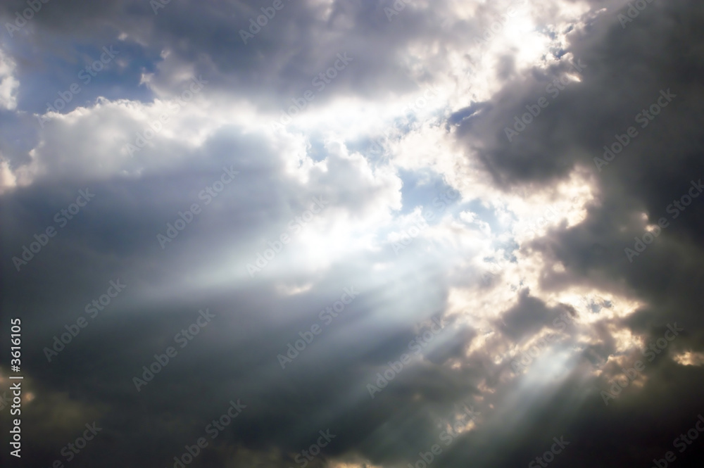 Sunbeams shining through storm clouds.