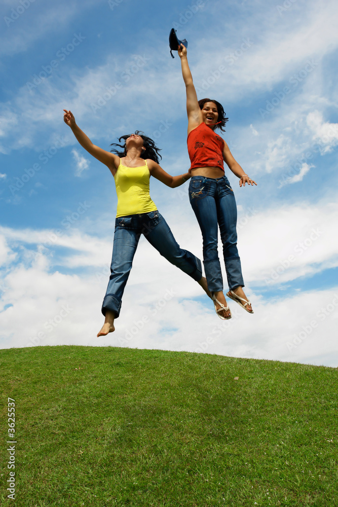 Salto de dos mujeres latinas sobre montaña Salto de dos mujeres latinas sobre montaña