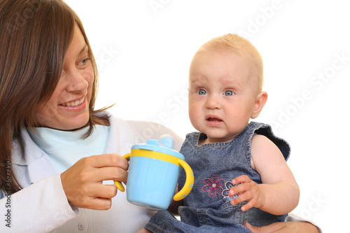 mother and 8 months baby girl with baby cup isolated 