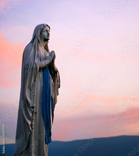 Fotografiet Statue de la vierge marie et coucher de soleil en Savoie.