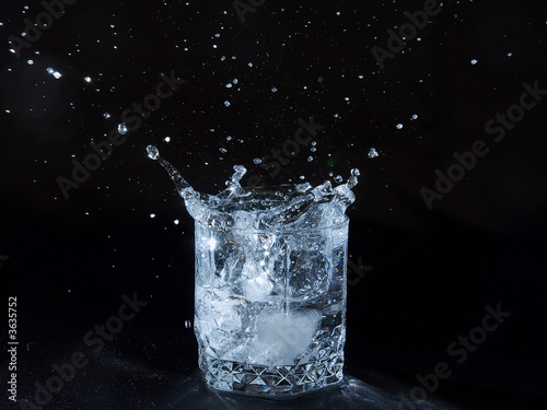 Ice splashing water in the glass