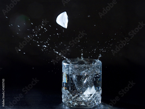 Ice splashing water in the glass