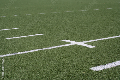 White line markers on a green American football field.