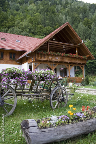 Mountain chalet with decorative cart in front