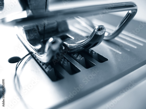 duotone close-up of a needle in a sewing machine