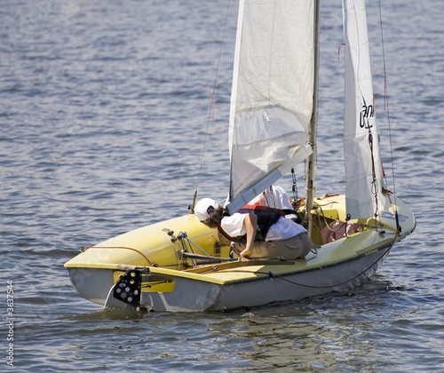 Young girl sailing with a little pleasure yach on a lake