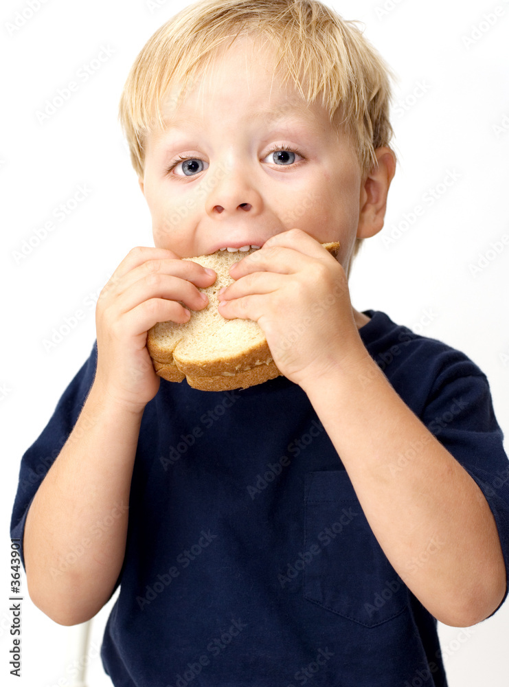 Boy taking a big bite of its peanut butter sandwich Boy taking a big bite of its peanut butter sandwich