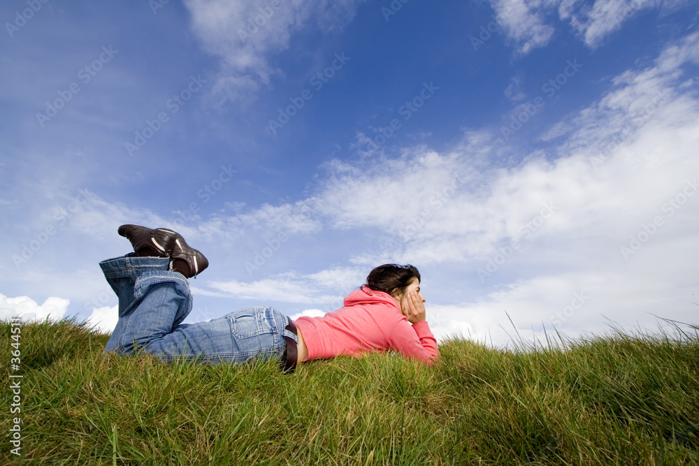Beautiful woman lying on grass with blue sky Beautiful woman lying on grass with blue sky