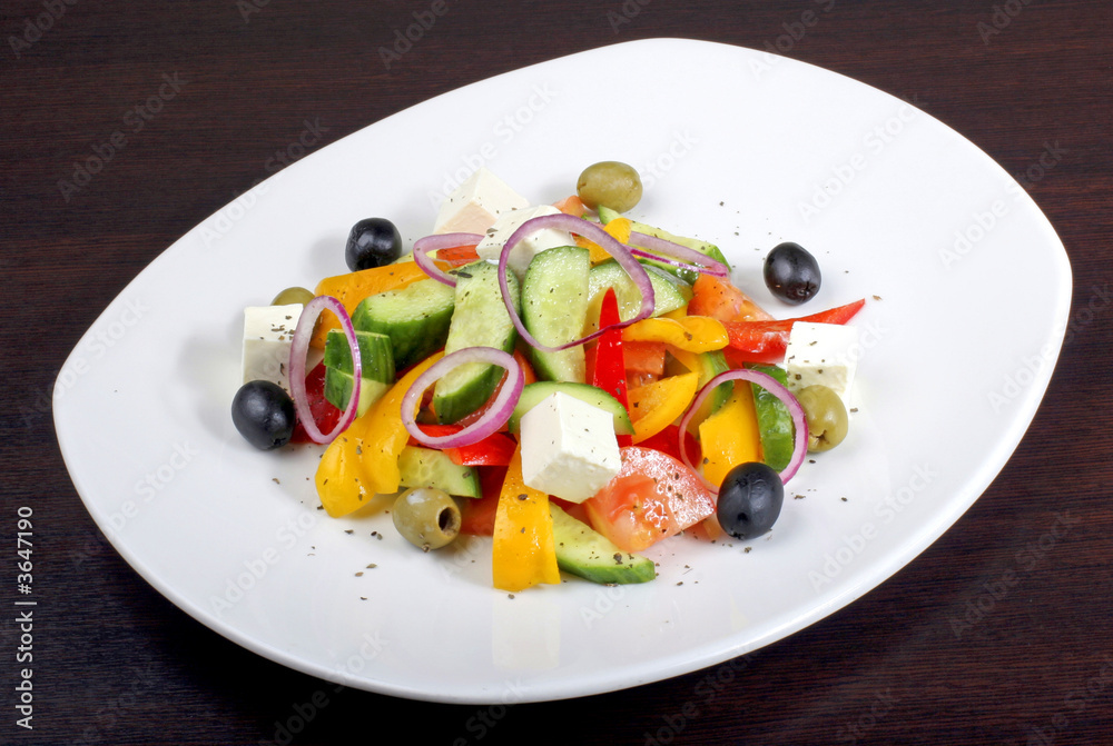 greek salad with vegetables on dark table