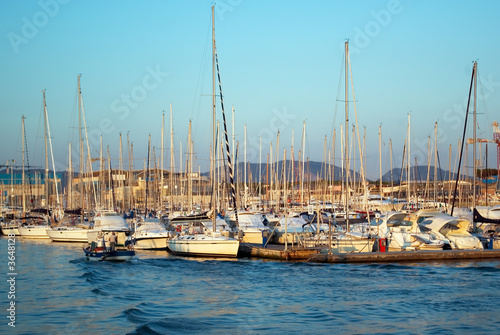 Yachts and sailboats in a port at sunset. © jon11