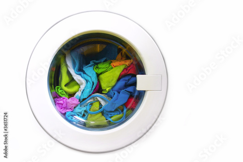 Close-up on a washing machine with clean colorful clothes