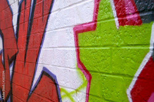 Graffiti sprayed on a brick wall, side perspective.