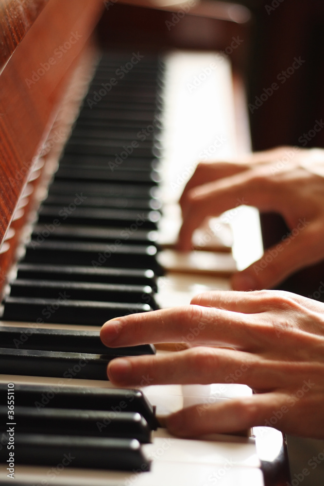Hands of a pianist, motion blur, focus on the left hand