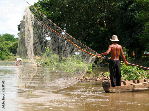 fisherman with large net in river